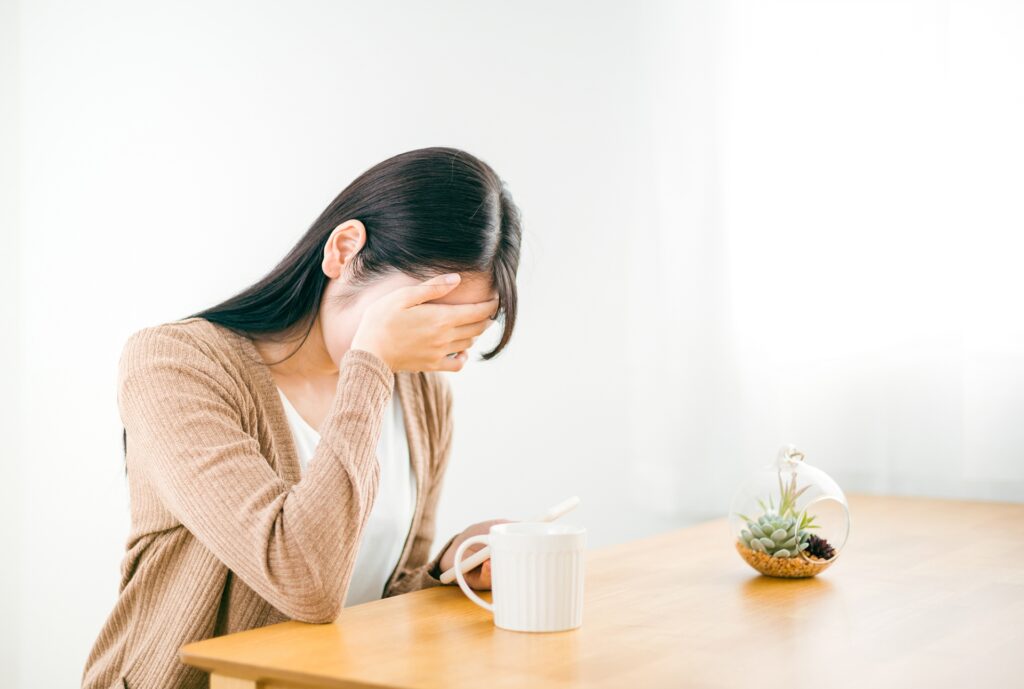 スマホを見てショックを受ける女性