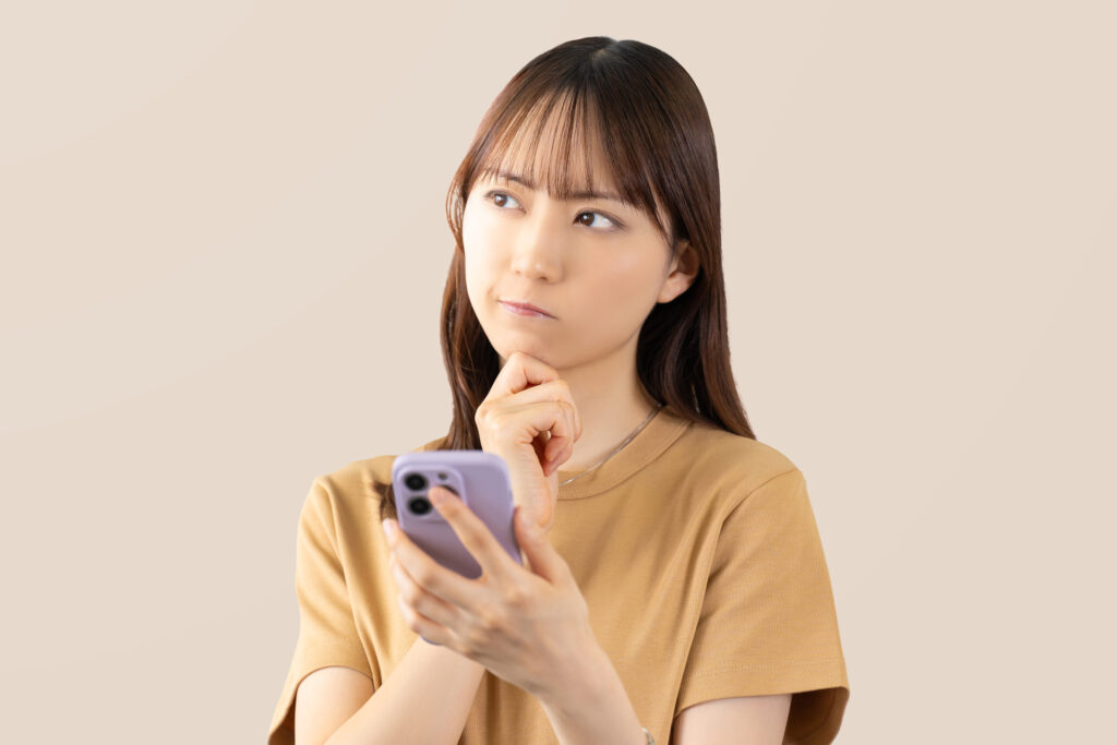 スマホを見て考える若い女性